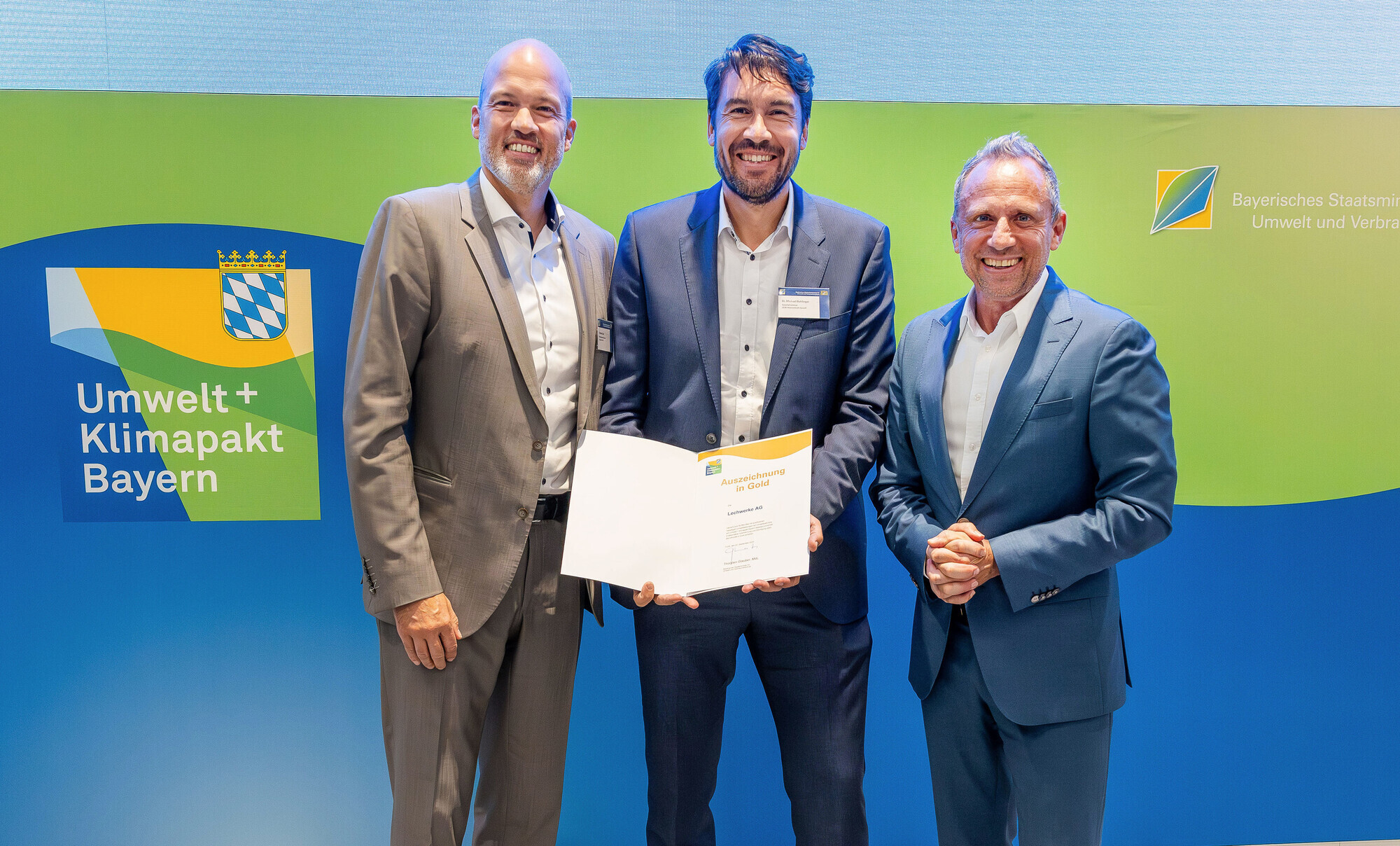 Bayerns Umweltminister Thorsten Glauber (r.) übergibt die Gold-Urkunde des Umwelt- und Klimapakts Bayern an LEW-Vorstand Christi